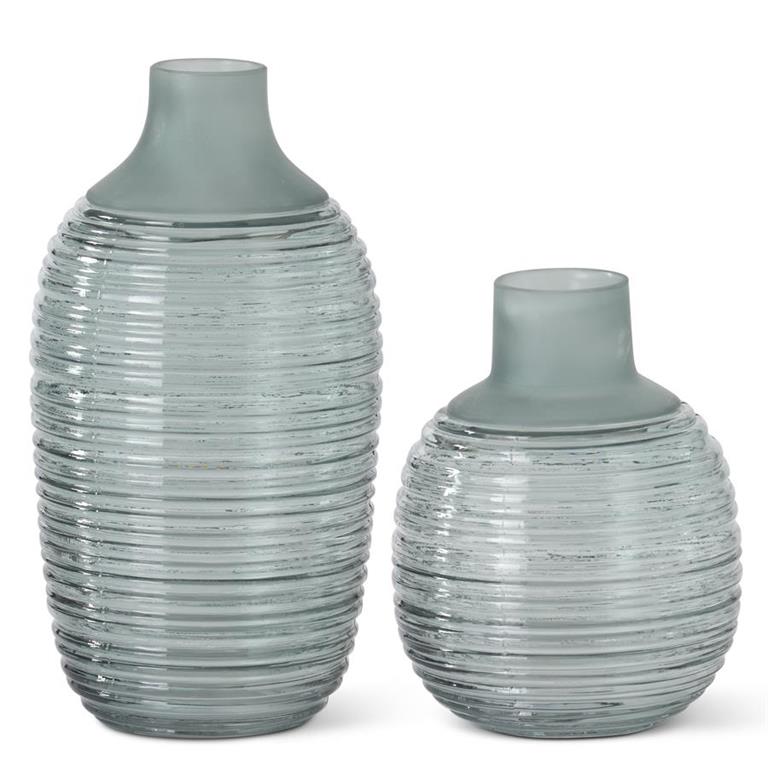 A set of two frosted sage green ribbed glass vases with a bottleneck shape.