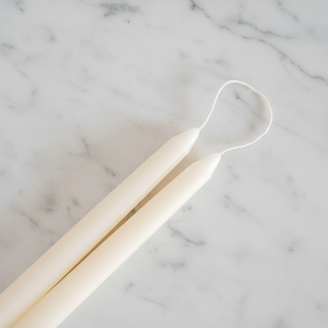 12-inch ivory taper candle pair against a white marble background.