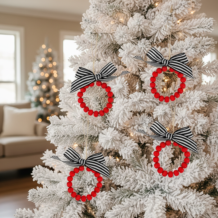 Decorative Christmas tree with red wreath ornaments and black and white bows in a home setting.