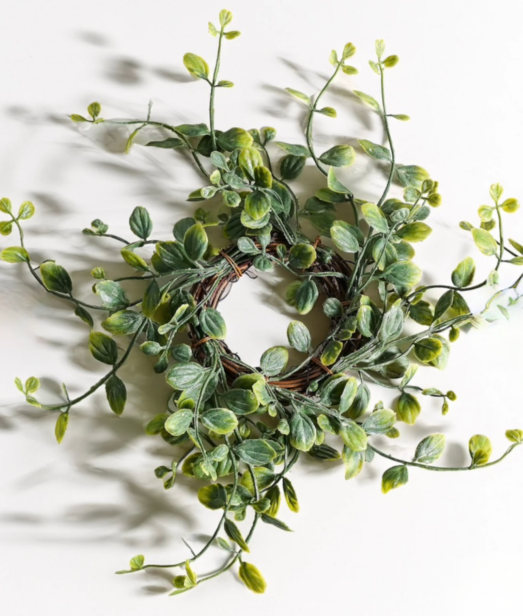 Artificial green leaf candle ring on a white background