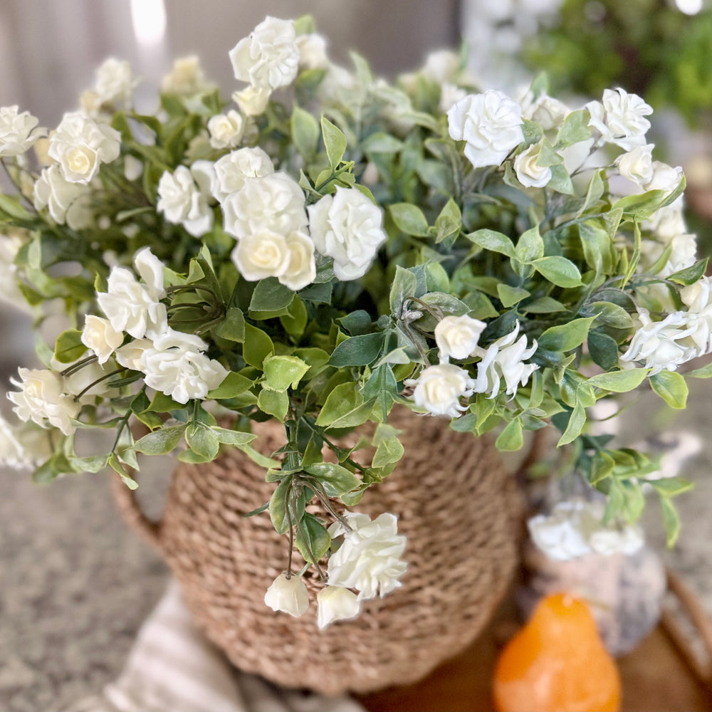 Bouquet of white flowers in a woven basket with a blurred background