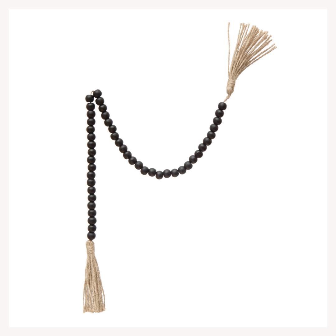 Black beaded garland with jute tassels on a white background