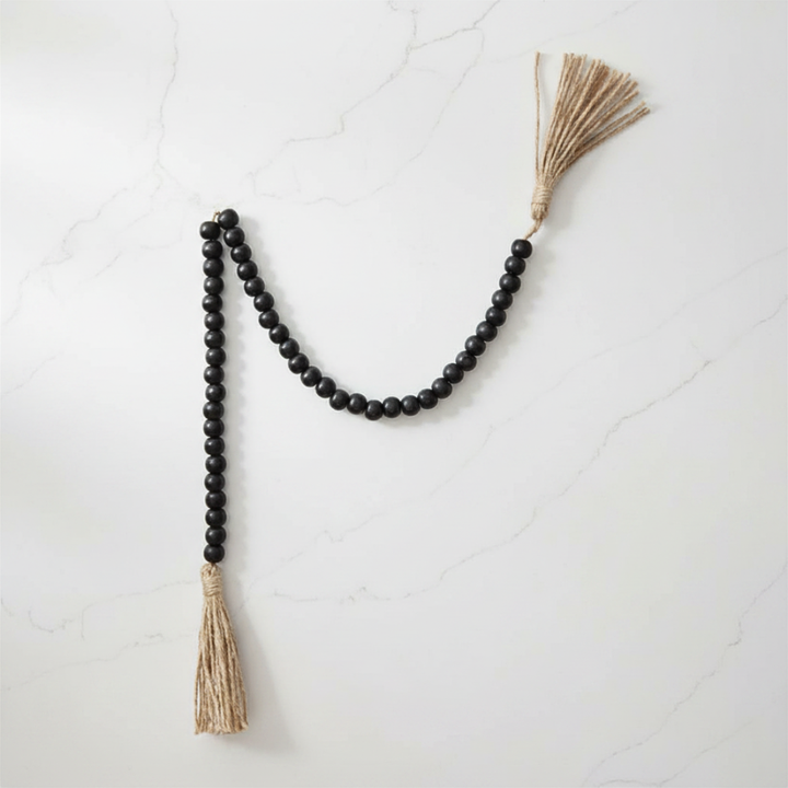 Black beaded garland with tassels on a white background