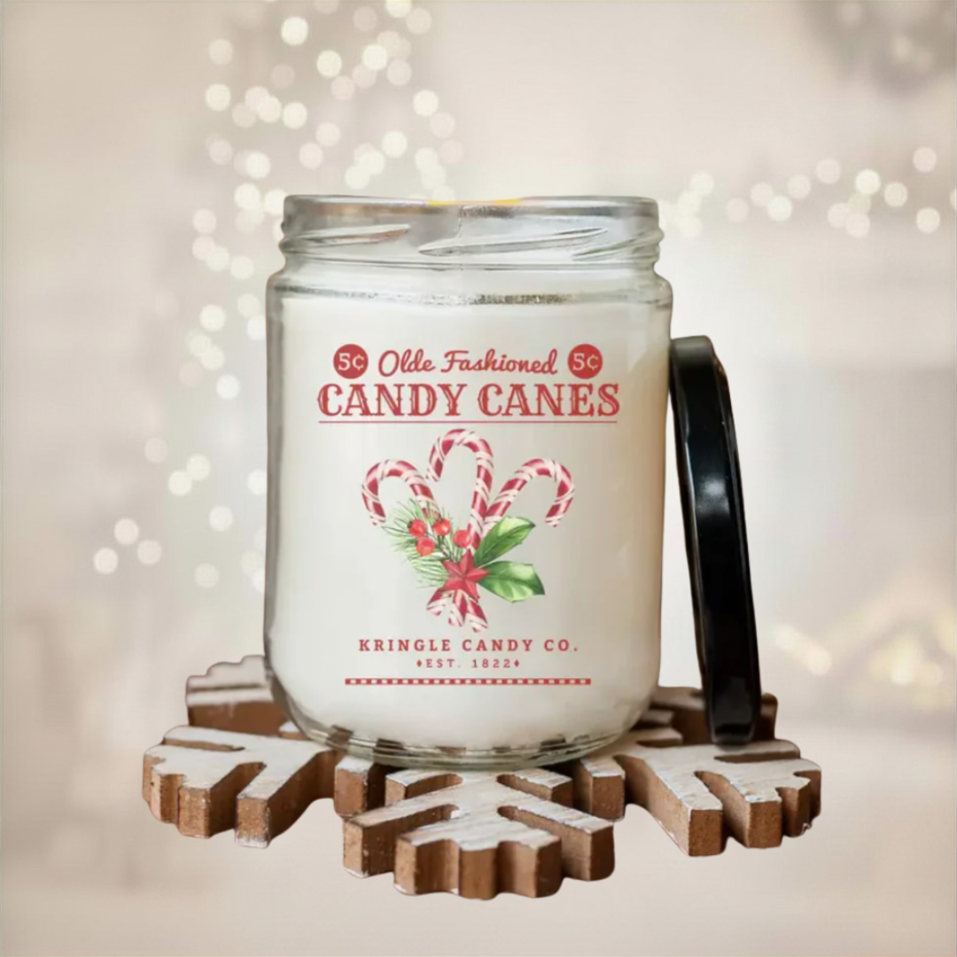 Candle in a jar with a candy cane design label on a decorative stand with a blurred light background