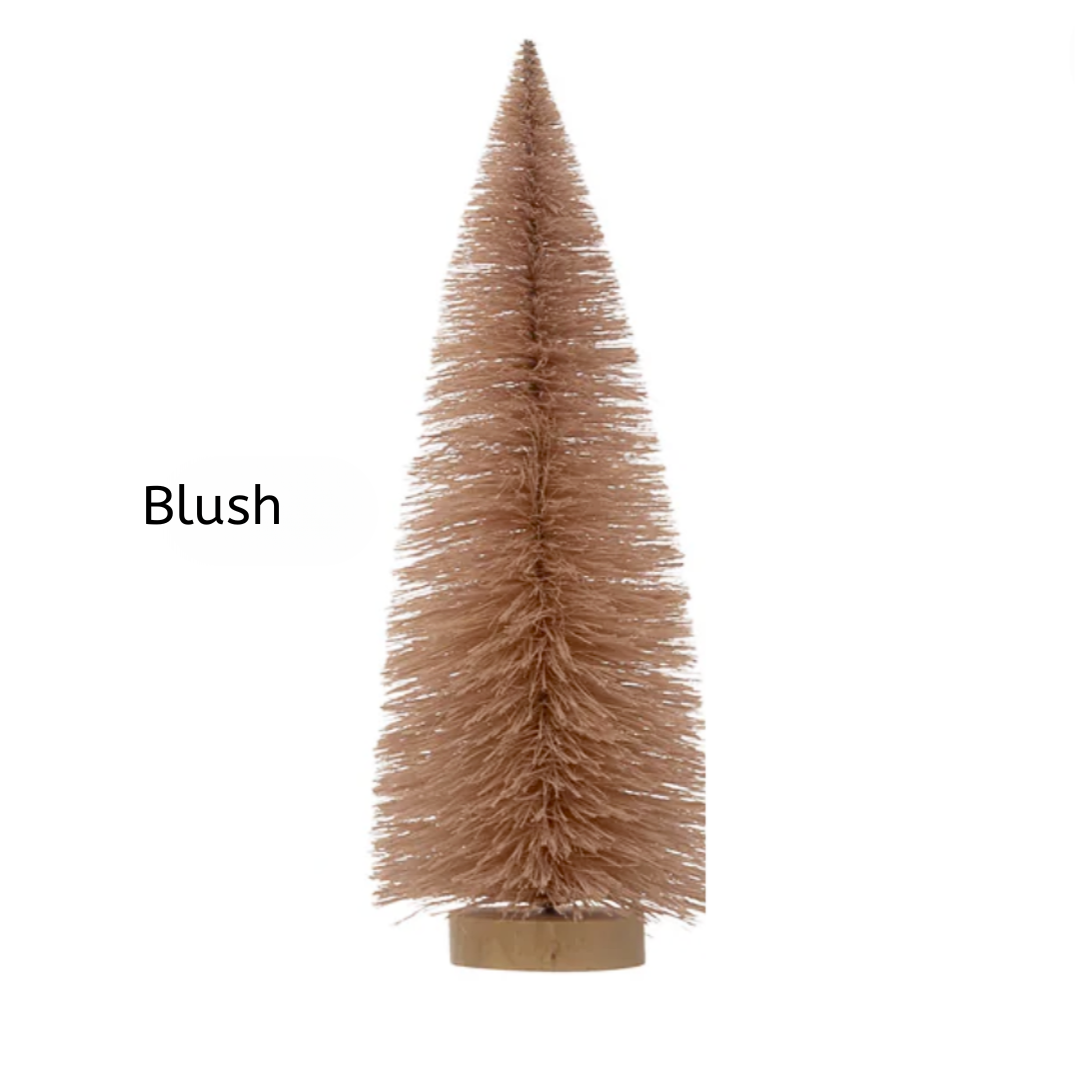 Blush-colored artificial Christmas tree on a white background