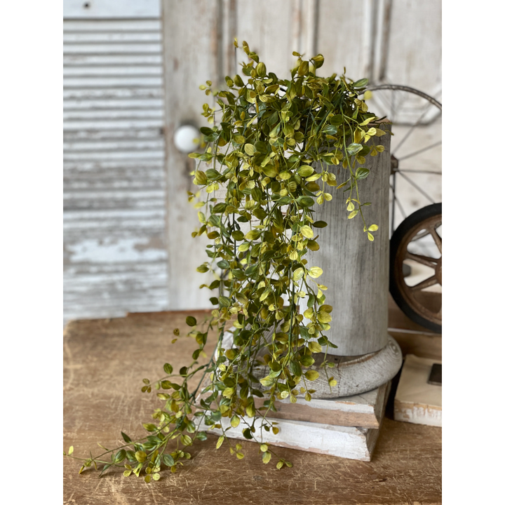 Artificial greenery on a wooden surface with a rustic background