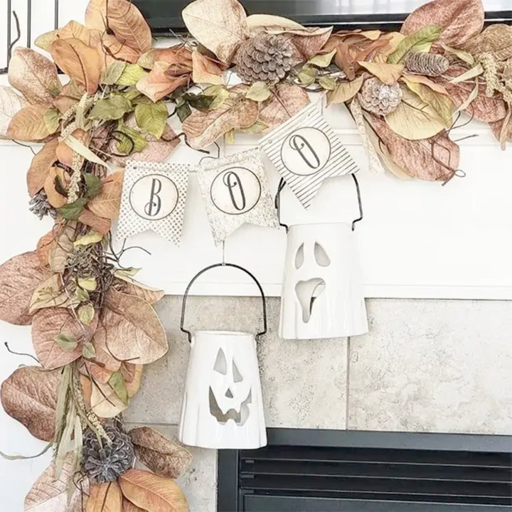 Decorative Halloween wreath with pumpkins, ghosts, and leaves on a fireplace.