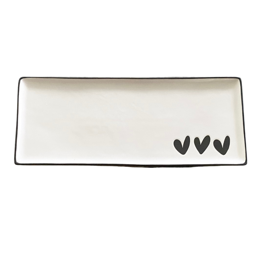 Rectangular white tray with black rim and three black hearts on a white background