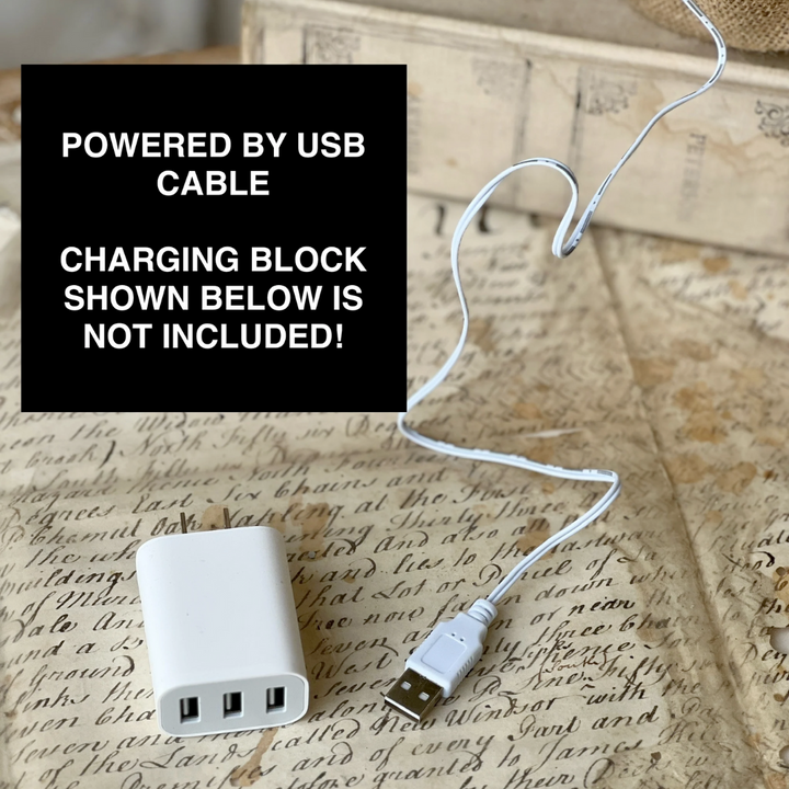 White charging block with USB cable on a textured surface with text