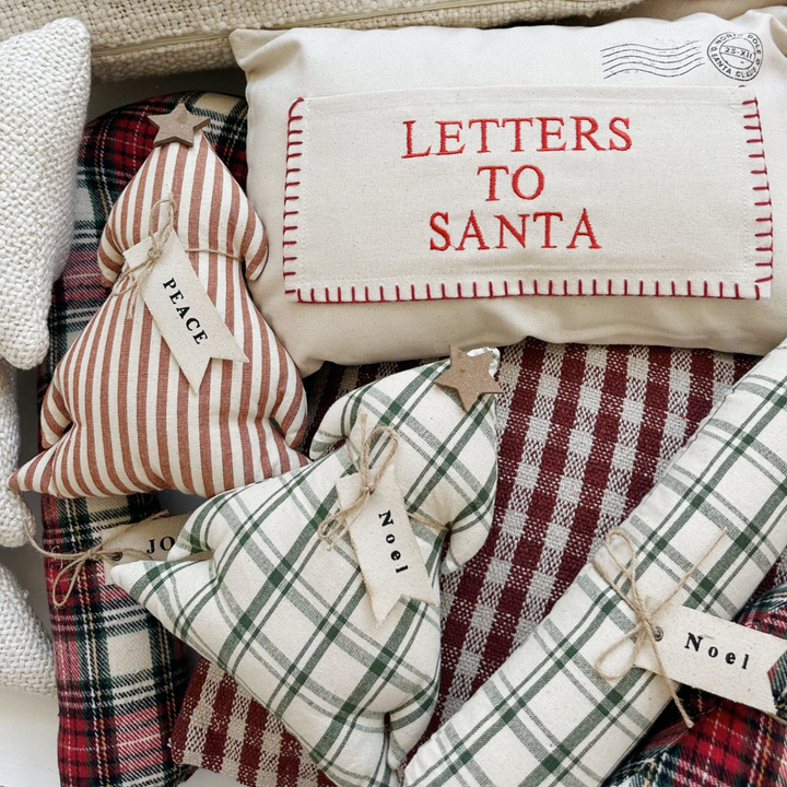 Decorative pillows with text and patterns, including 'Letters to Santa' and 'Noel'.