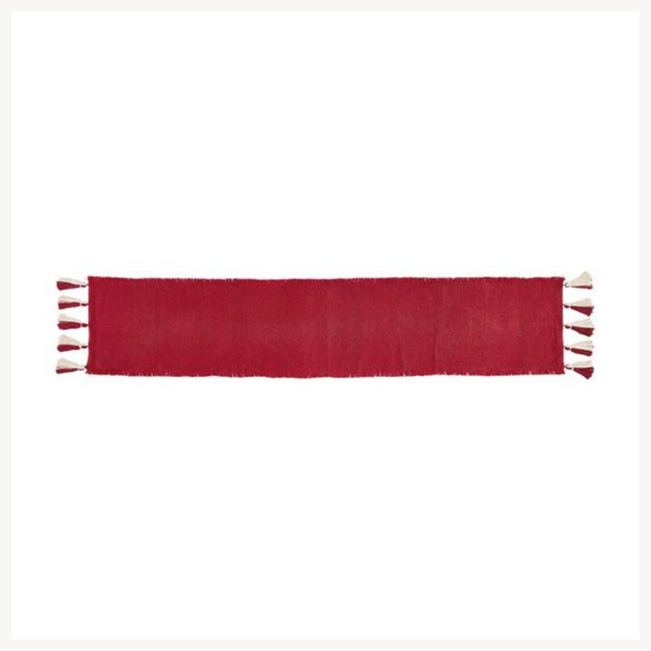 Red table runner with red and white tassels on a white background