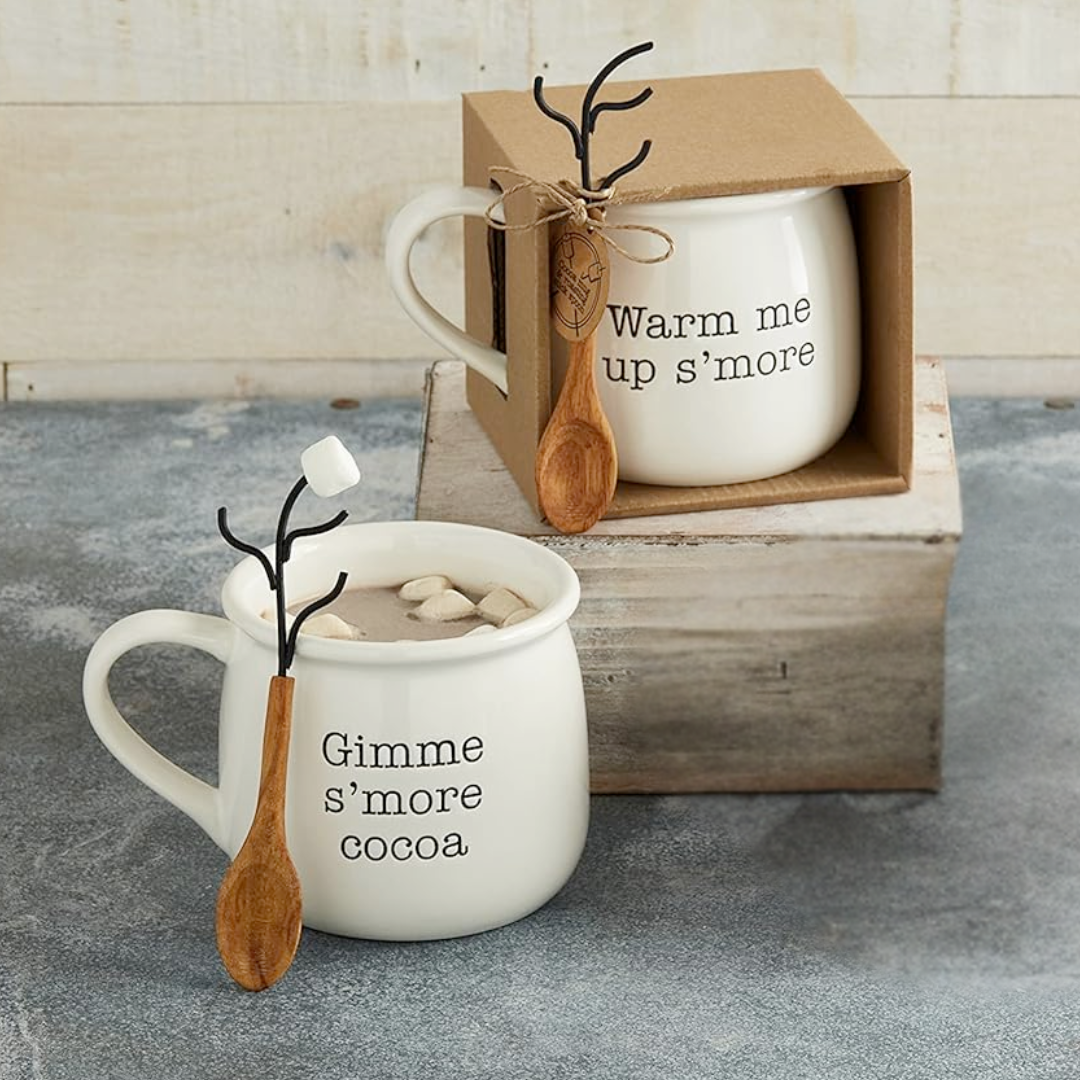 Two white mugs with text and wooden spoons on a gray surface.