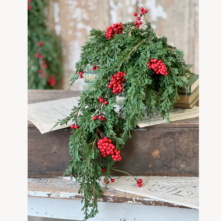 Decorative greenery with red berries on a rustic wooden surface