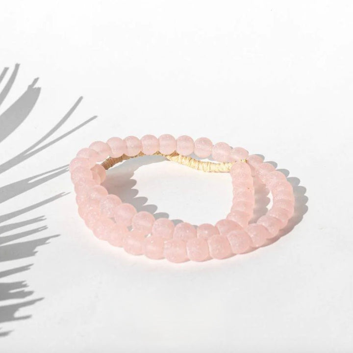 A pink glass bead garland with asymmetrical design, likely used for home decor.