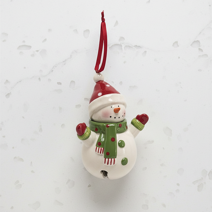 Decorative snowman bell ornament with a red hat and green scarf on a light gray background.