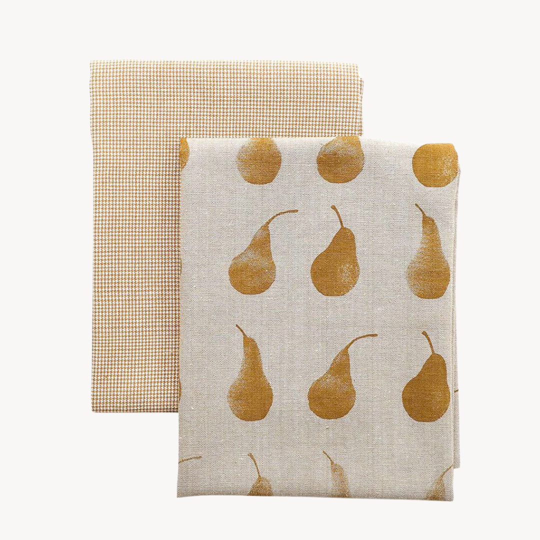 Two cotton tea towels, one with a Duchess Pear motif and the other featuring a gold and cream mini check pattern.