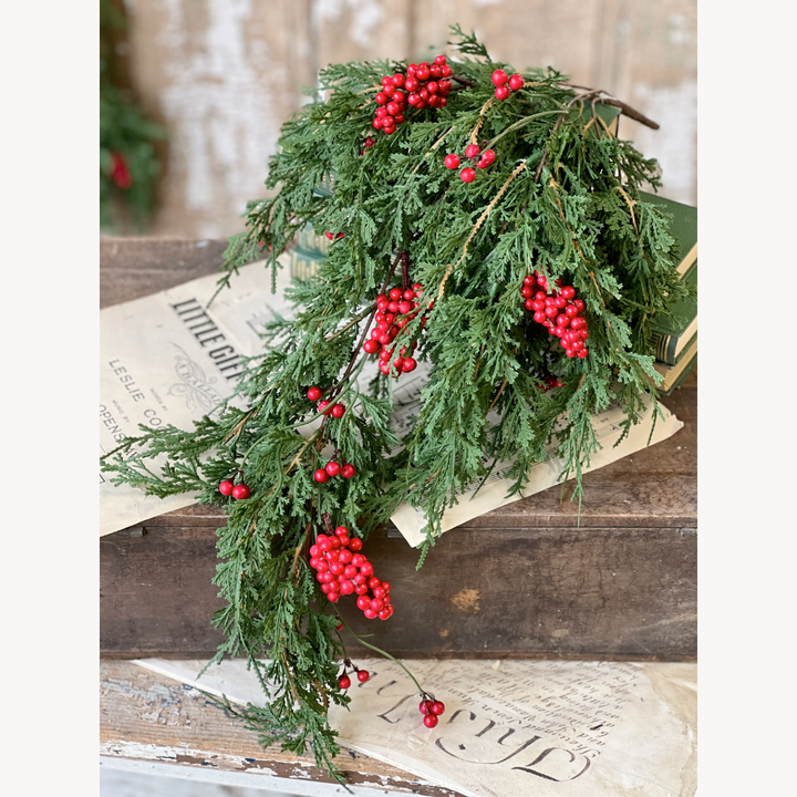 Decorative greenery with red berries on a wooden surface