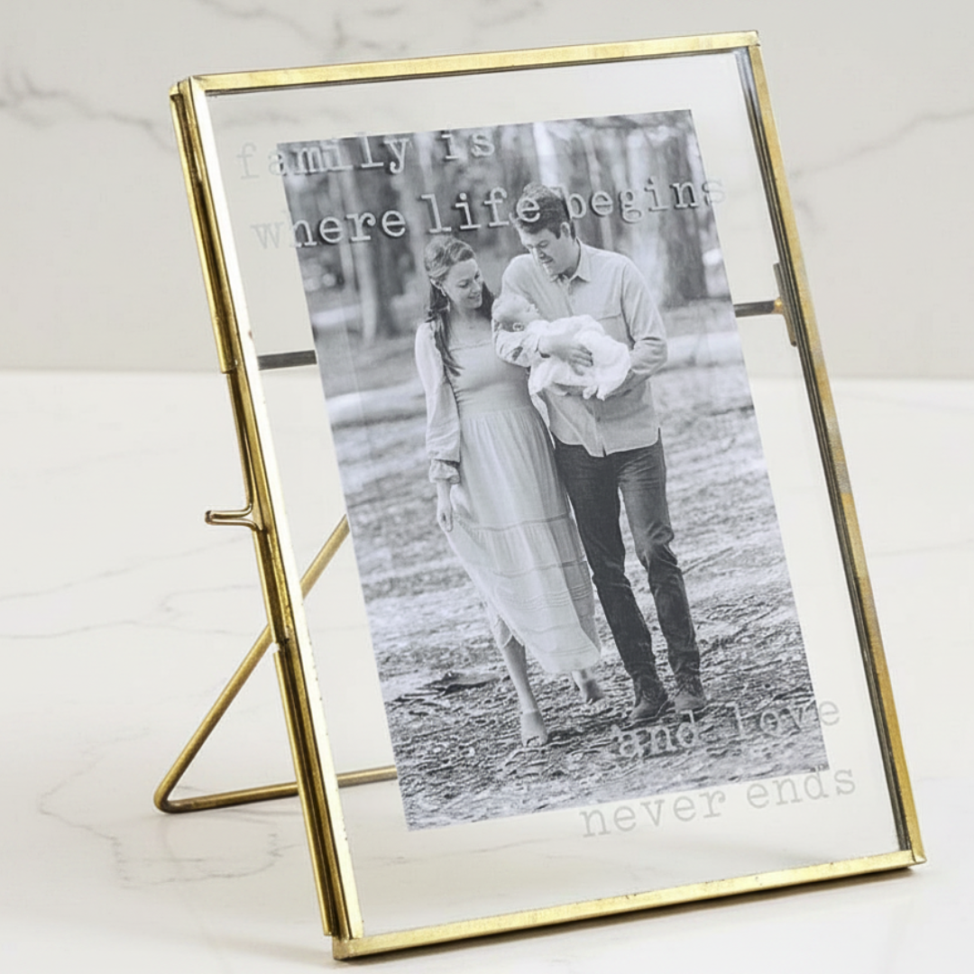 Gold-framed photo of a couple with text on a nightstand in a bedroom.