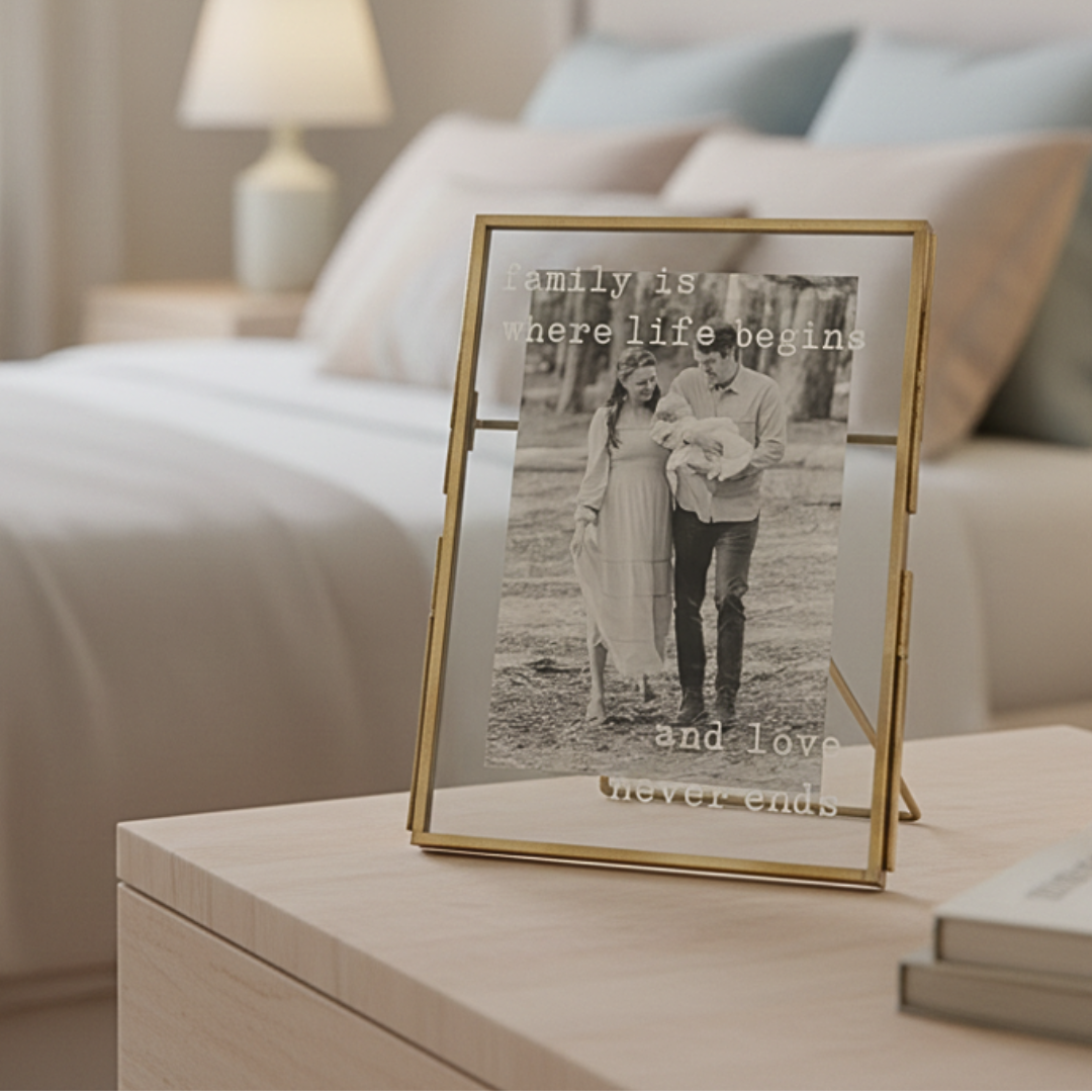 Gold-framed photo of a couple with text on a nightstand in a bedroom.