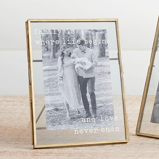 Two gold photo frames on a wooden surface with white background