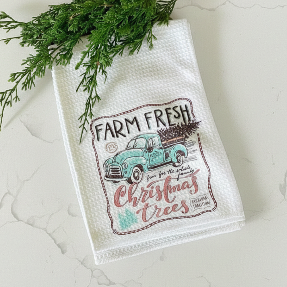 Decorative kitchen towel with a Christmas truck design on a textured surface.