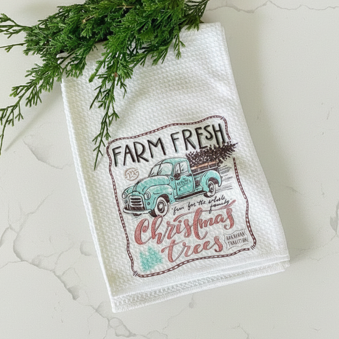 Decorative kitchen towel with a Christmas truck design on a textured surface.