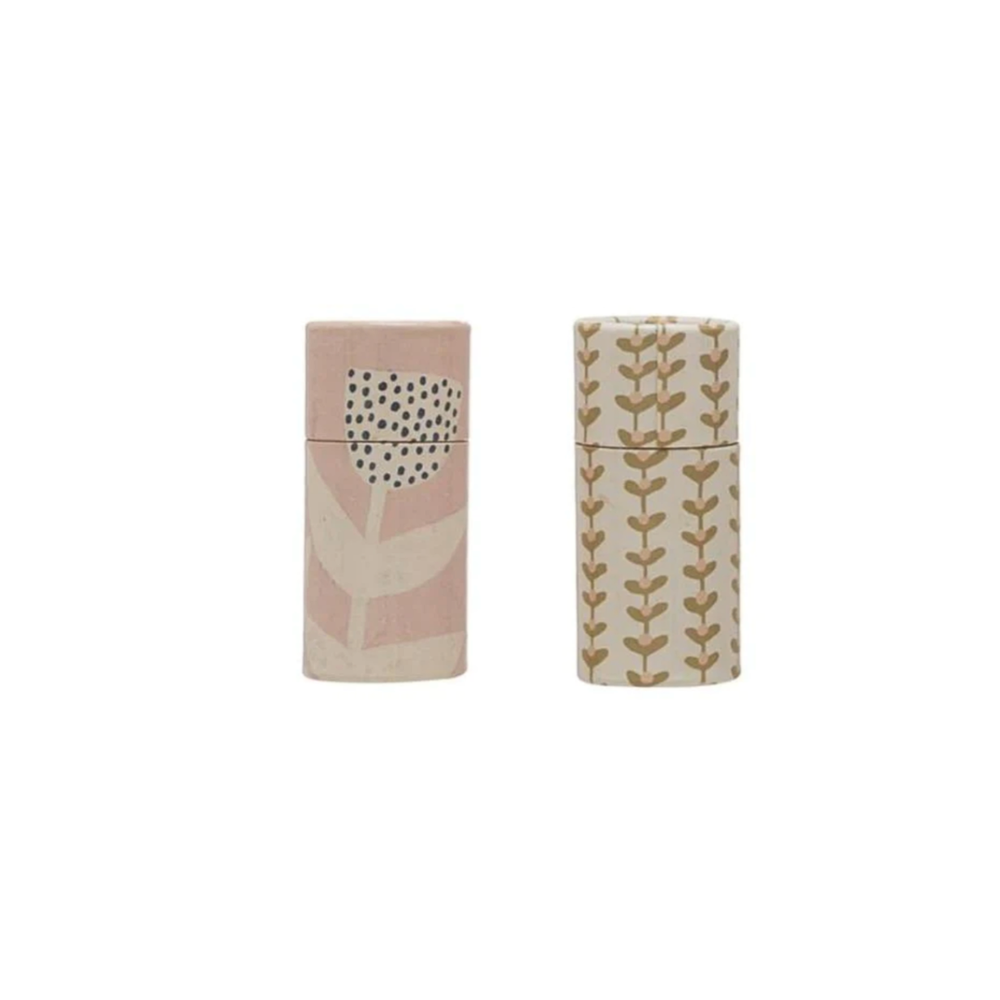Two small floral tube matches with decorative patterns on a white background