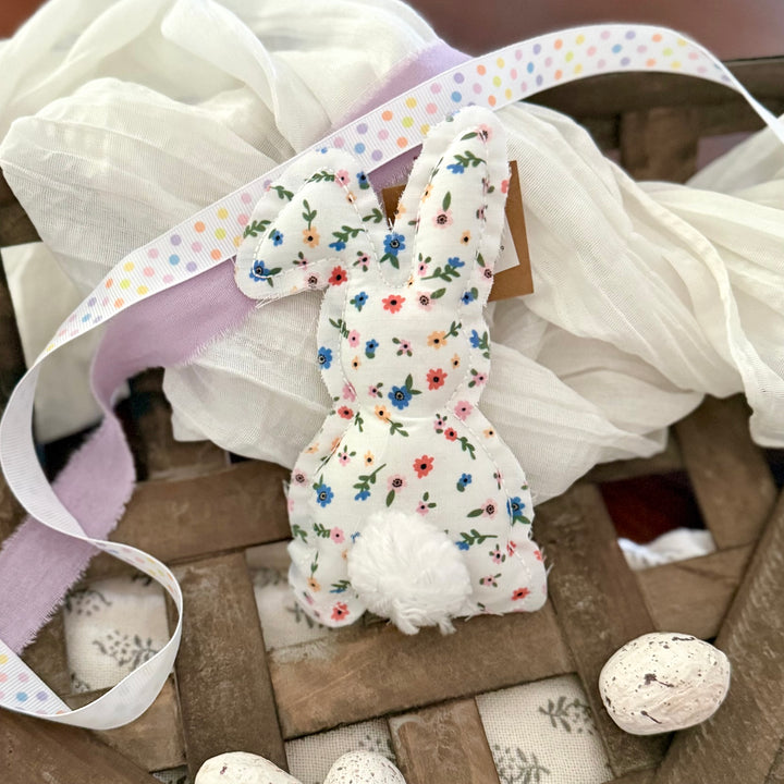 Decorative bunny with floral pattern on a wooden surface with a ribbon