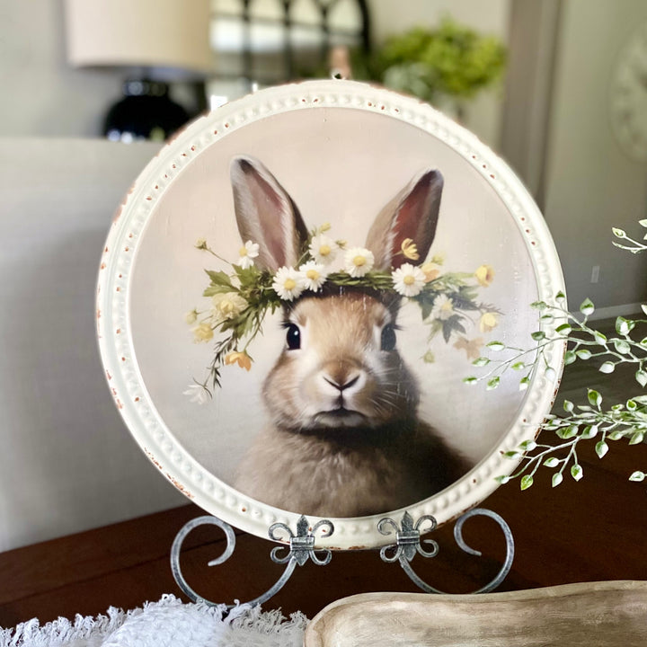 A decorative print of a bunny wearing a flower crown, displayed in a distressed white frame with beaded details.