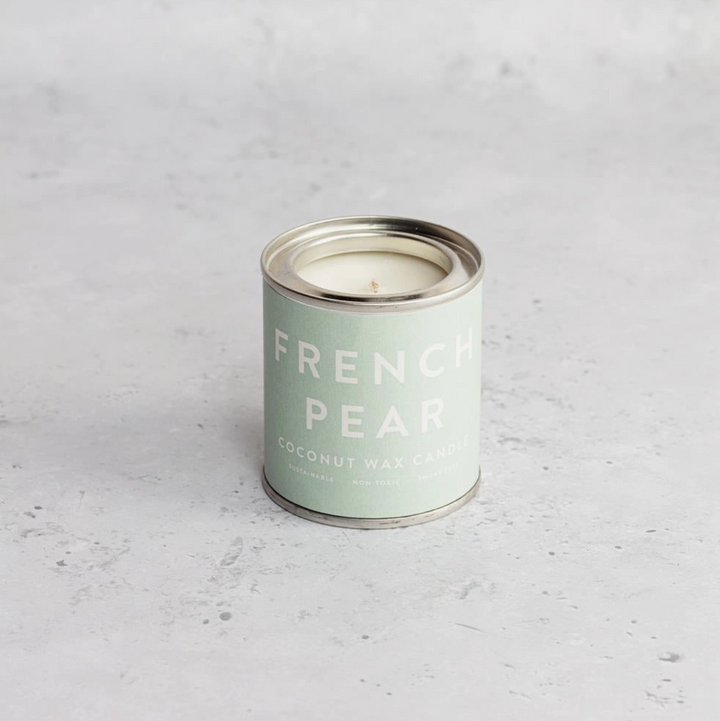 A collection of Conscious Coconut Wax Candles in various colors, displayed in reusable and recyclable paint tins.