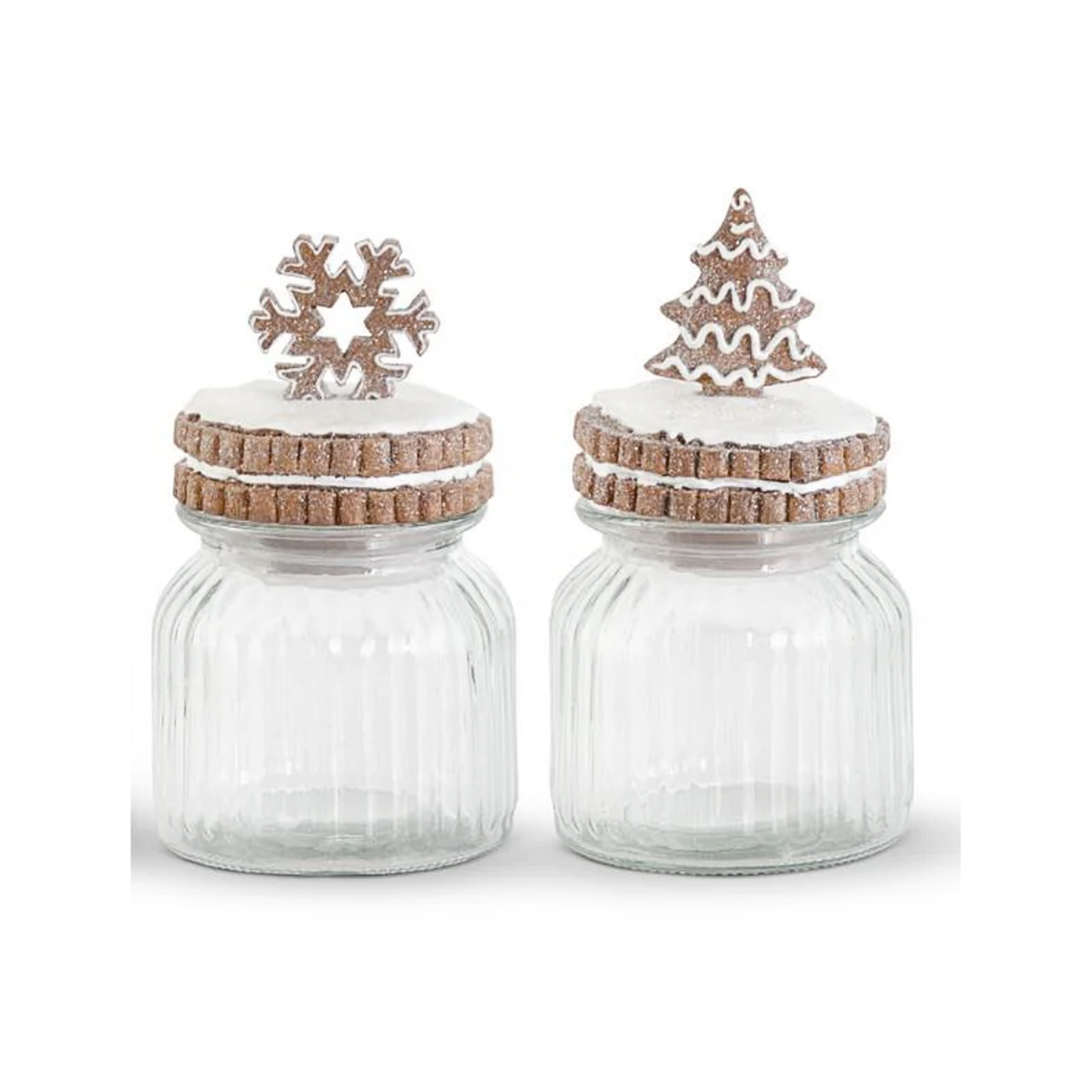 Two glass jars with decorative wooden lids featuring snowflake and tree designs on a white background.