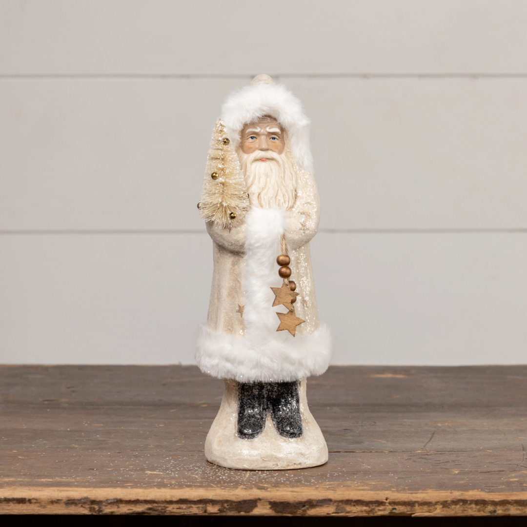 Decorative Santa figure of a bearded man in a long coat with white fur trim on a wooden surface.