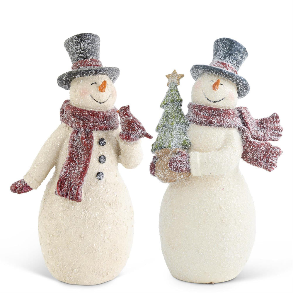 Two snowman figurines with top hats and scarves, one holding a tree, on a white background.