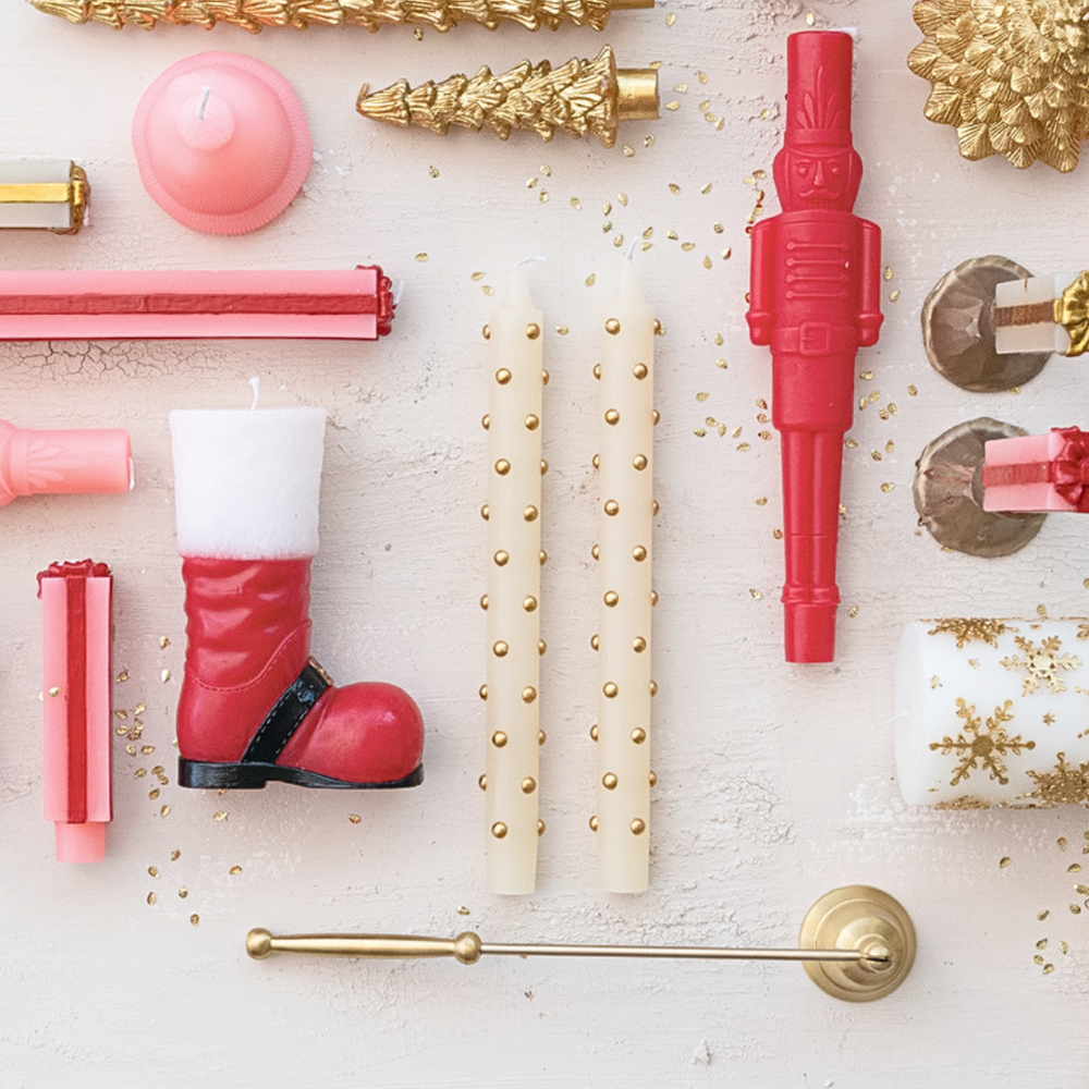 Decorative items including candles, a boot-shaped object, and gold accents on a light background