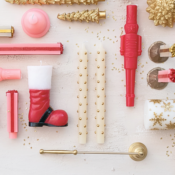 Decorative items including candles, a boot-shaped object, and gold accents on a light background