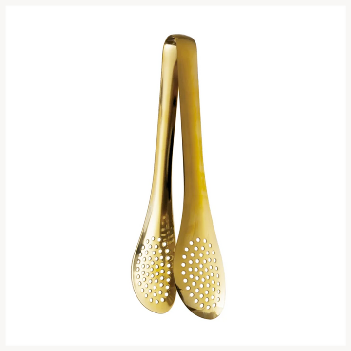 A pair of gold-finished stainless steel slotted tongs with small holes for serving or cooking.