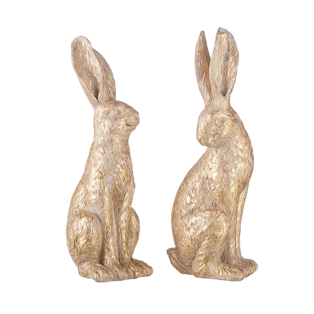 Two gold rabbit statues on a white background