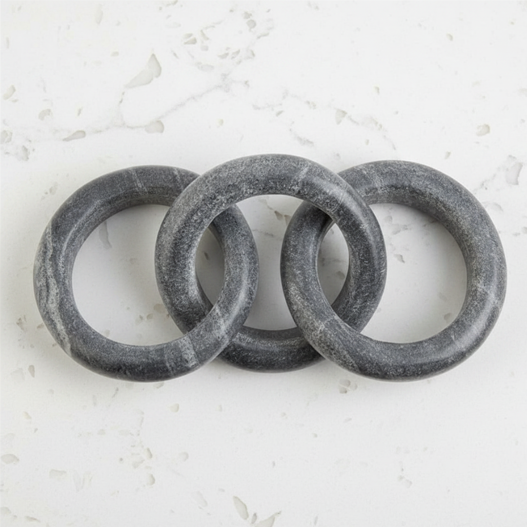 Three gray marble links on a textured white background