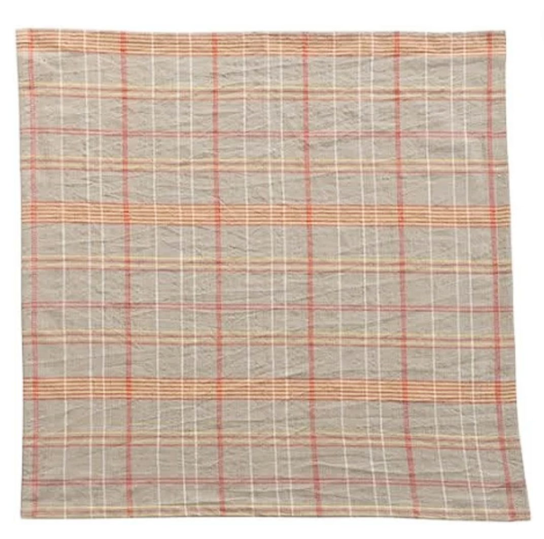 Plaid patterned napkin in gray and orange colors on a white background