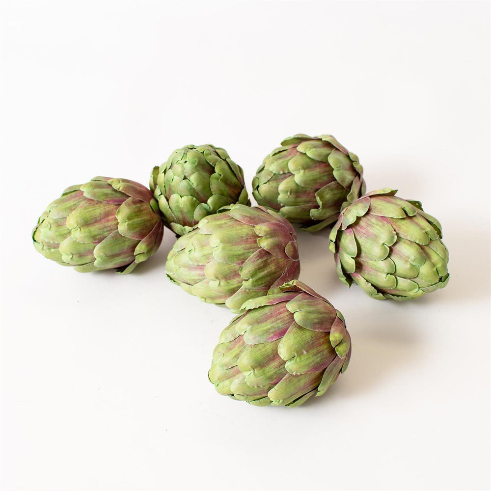 Five green faux artichokes on a white background