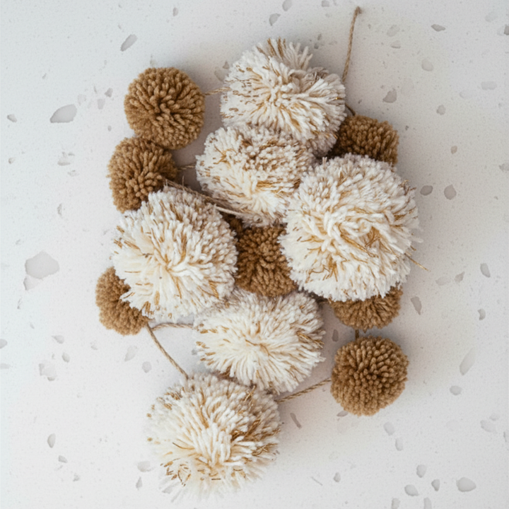 Brown and white pom-poms on a light gray background