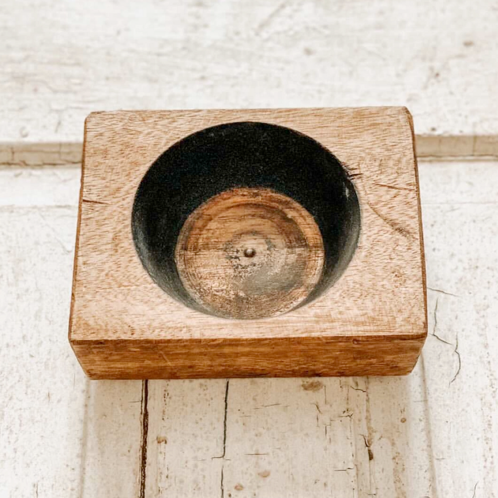 Wooden block with a circular cutout on a light wooden surface
