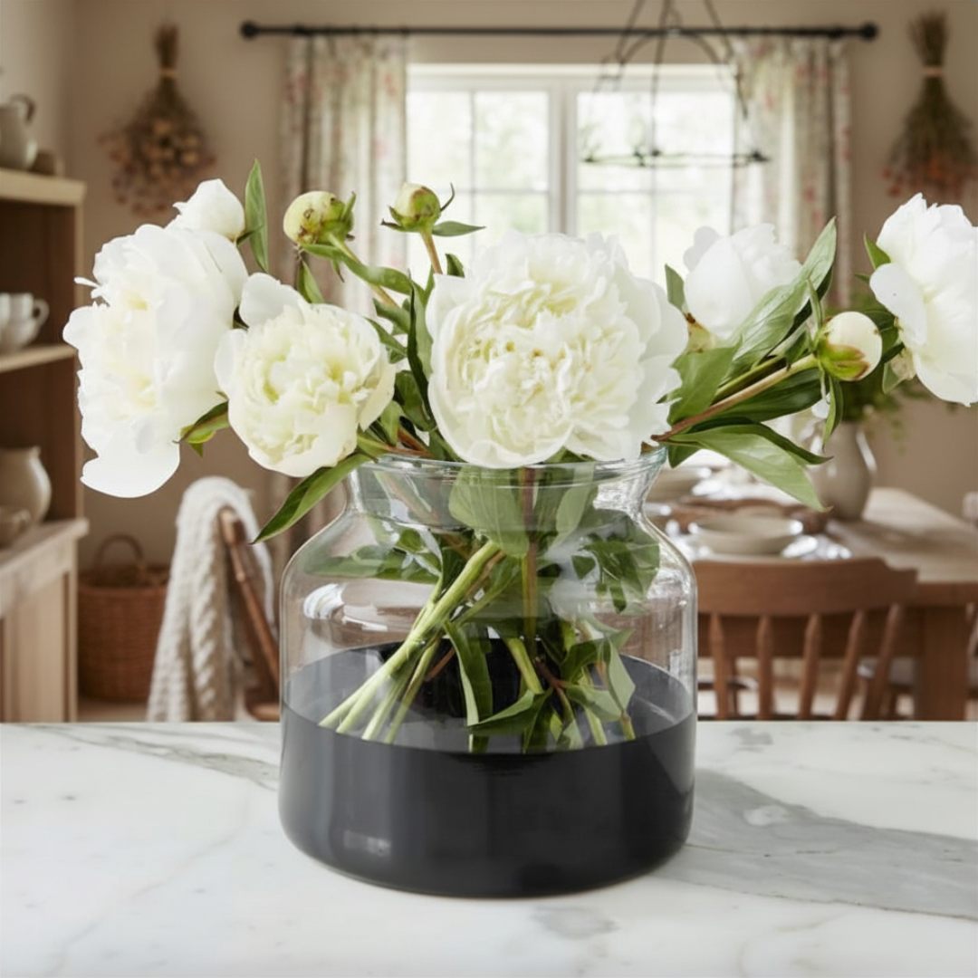 Clear vase with white flowers on a marble surface in a home setting