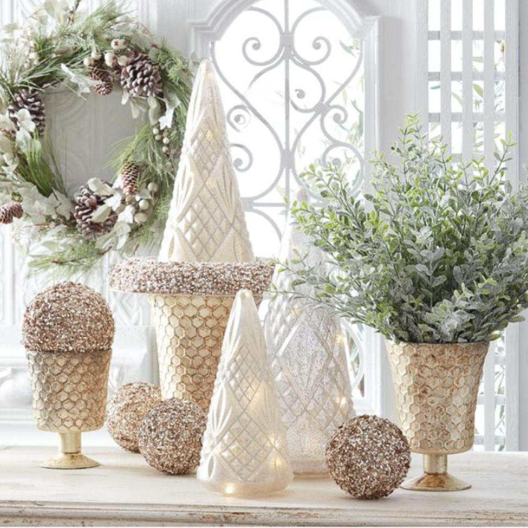 Honeycomb Champagne Mercury Glass Fluted Vase with decorative Christmas trees and ornaments on a table with a white lattice background