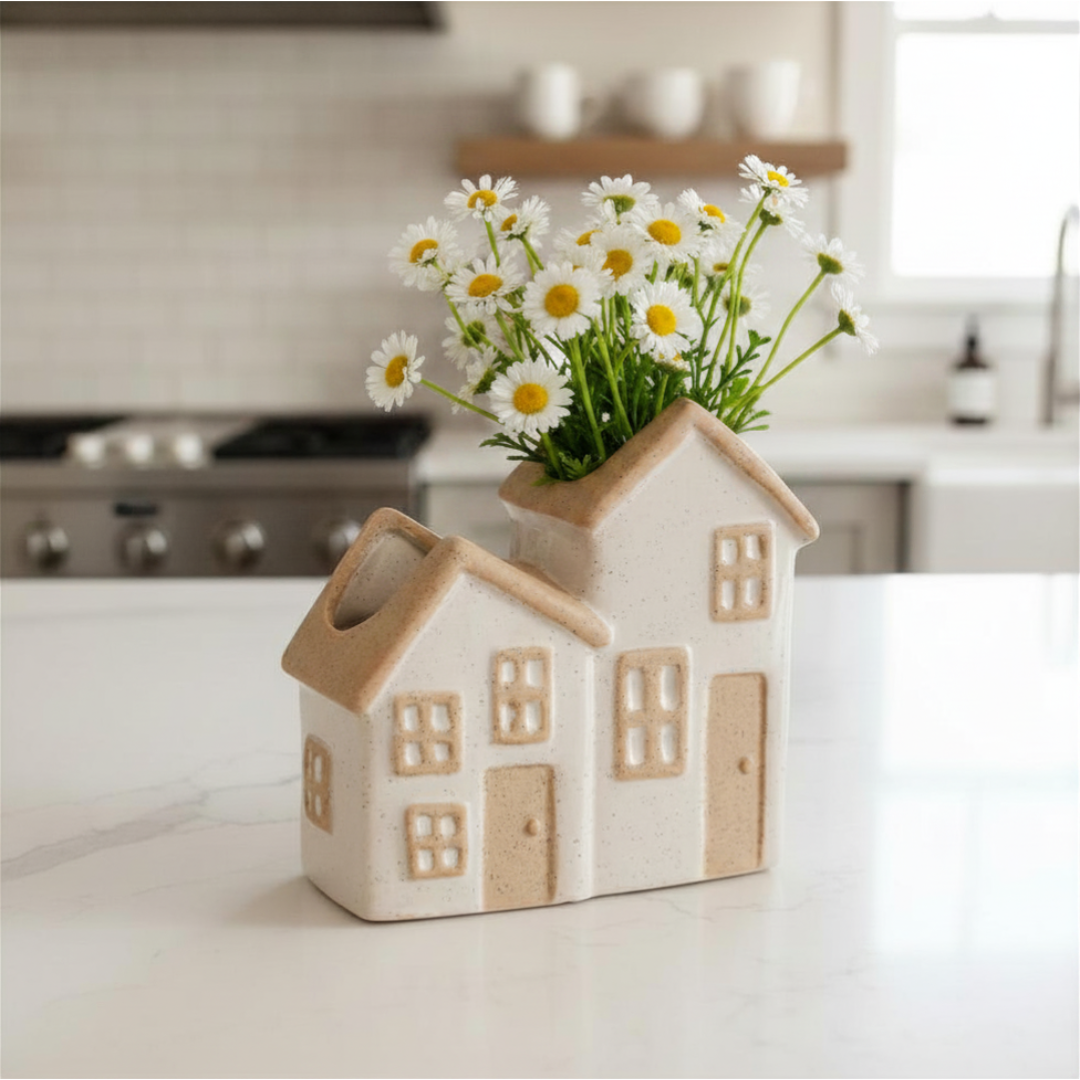 House-shaped vase with flowers on a kitchen counter