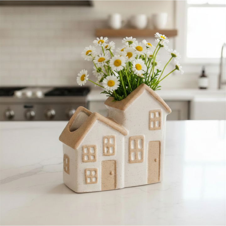 House-shaped vase with flowers on a kitchen counter