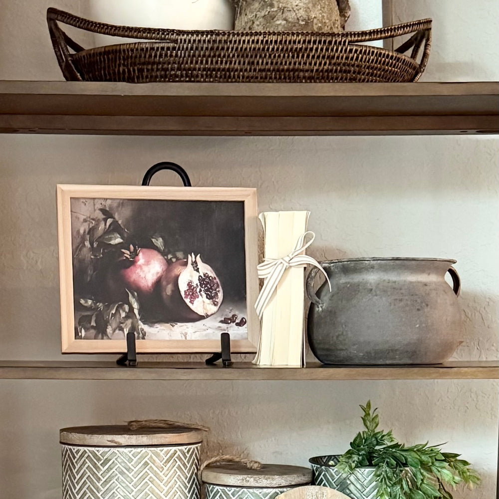Decorative shelf with a framed photo, vase, and other items against a neutral wall.