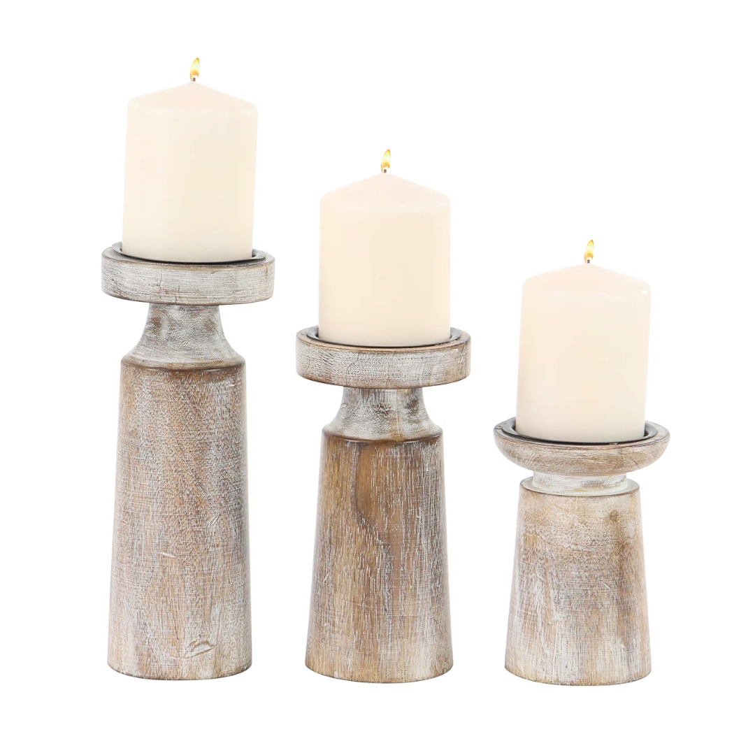 Three mango candle holders with candles on a white background