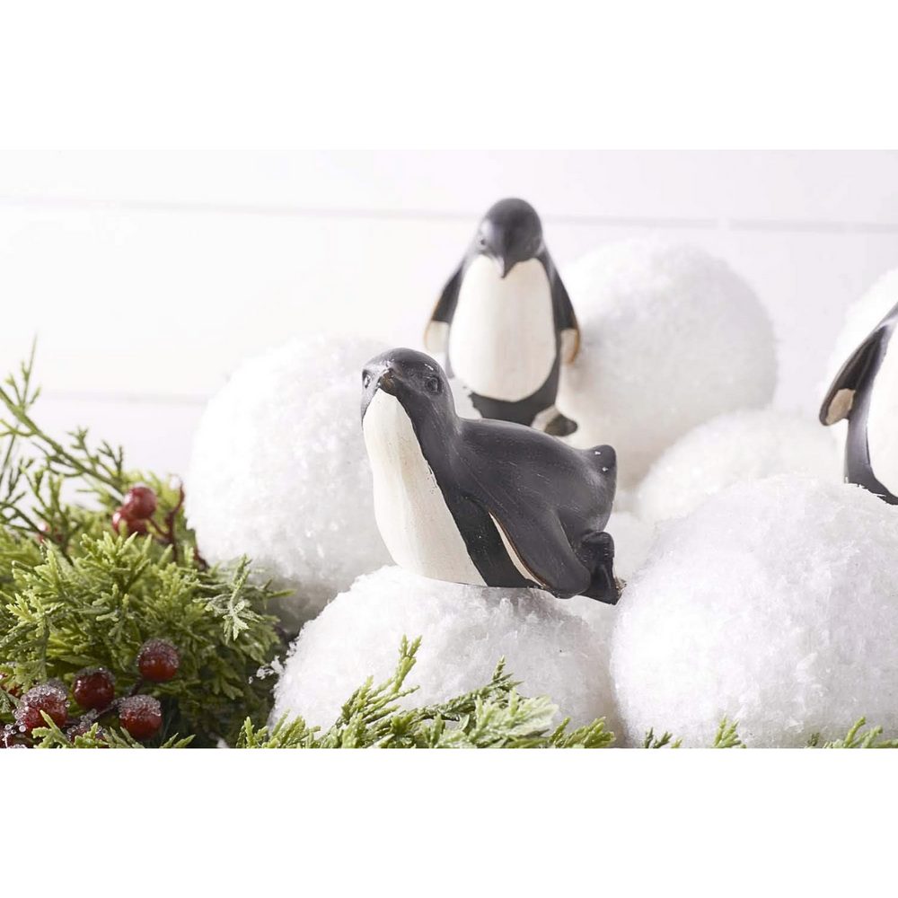 Decorative penguins on a snowy background with greenery and textured snowball ornaments