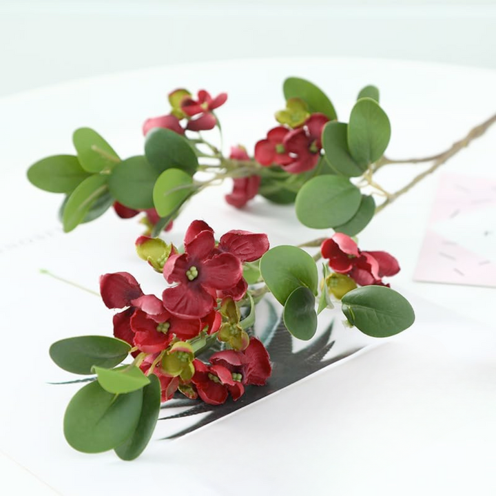 Burgundy flowers and green leaves on a white background